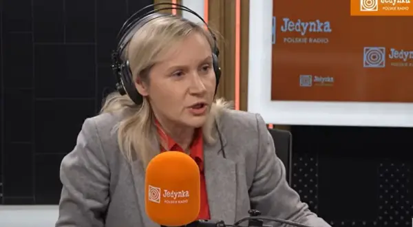 Kobieta w słuchawkach, przypominająca żonę Michała Rachonia, udziela wywiadu w studiu Polskiego Radia Jedynka.