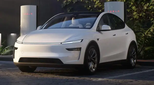 Biała Tesla zaparkowana przy ładowarce Supercharger.