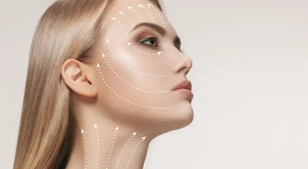 Profilo di donna bionda con frecce bianche che indicano le aree del viso e del collo, suggerendo come rimpolpare il viso per un aspetto più giovane e tonico.