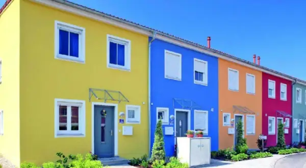 Reihenhäuser in leuchtenden Farben: Gelb, Blau, Orange, Pink. Tolle hausfassade farbe ideen für ein fröhliches Zuhause.