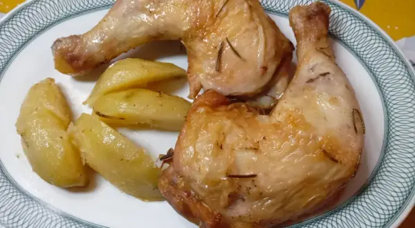 Cosce di pollo dorate e patate a spicchi, un piatto perfetto preparato nella friggitrice ad aria.