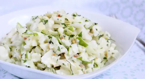 Ein **schneller Kohlrabisalat** mit Apfelstücken, Mandelsplittern und Petersilie in einer weißen Schüssel.