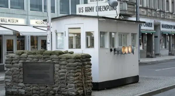 Checkpoint Charlie, dawne miejsce kontroli granicznej, z workami z piaskiem i tablicą pamiątkową.