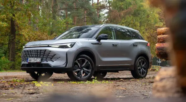 Srebrny SUV na leśnej drodze. Wiele osób szuka baic 7 opinii przed zakupem.