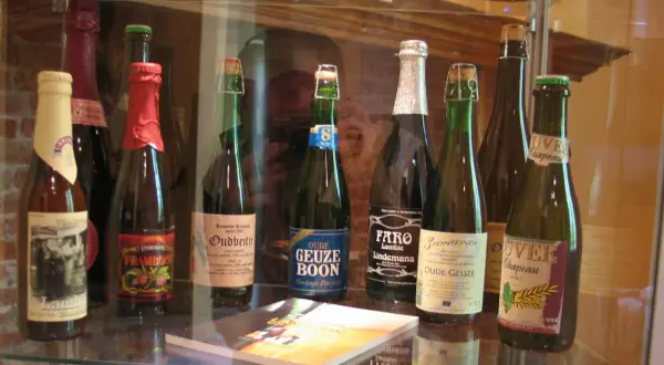 Rząd butelek piwa Lambic, w tym Oude Geuze Boon i Faro Lindemans.