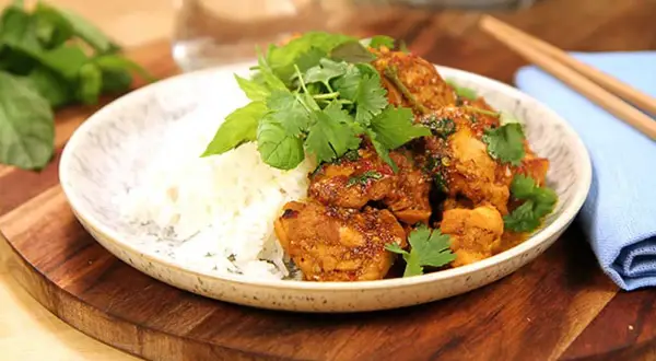 Kycklingrätt med ris, toppad med färska örter och en hint av citrongräs. En smakrik asiatisk måltid.