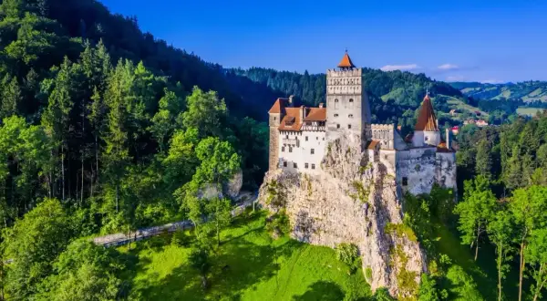 Zamek Bran, jedna z głównych rumuńskich atrakcji, majestatycznie wznosi się na skale pośród zielonych wzgórz i lasów.