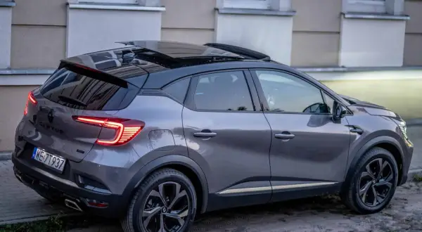 Szary Renault Captur z czarnym dachem i panoramicznym szyberdachem, idealny do miasta. Wiele pozytywnych renault captur opinie potwierdza jego wszechstronność.