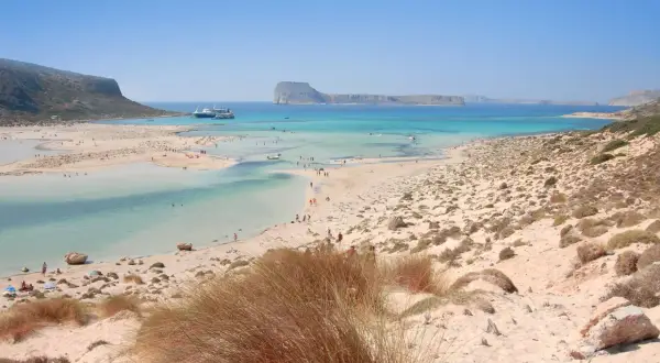 Piękne plaże na Krecie, Chania. Turkusowa woda, piaszczyste wybrzeże i góry w tle.