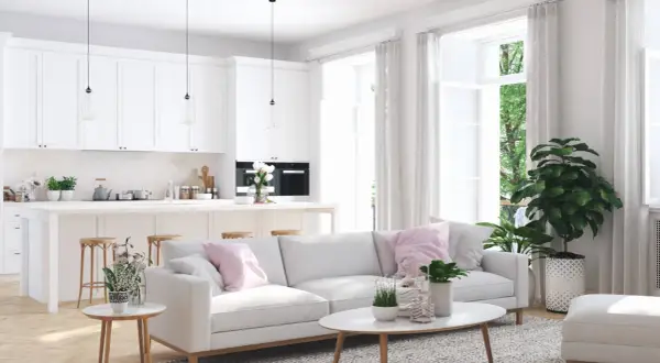 Illuminazione perfetta per un abbinamento lampadari open space: tre pendenti moderni sopra l'isola cucina e un'atmosfera accogliente nel soggiorno.