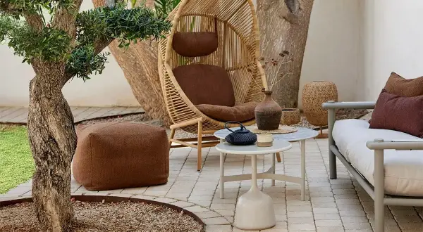 Gemütliche kleine Terrasse gestalten: Rattan-Sessel, Hocker, Sofa und Beistelltische laden zum Entspannen ein.
