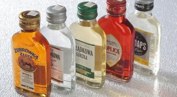 Pięć małych butelek wódki: Żubrówka Złota, Krupnik, Łagodowa Gorzka z miętą, Soplica Malinowa iaps Luxe. Zastanawiasz się, ile kosztuje setka?