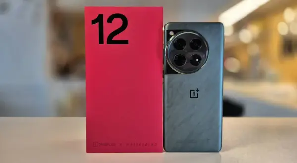 Czerwone pudełko z cyfrą 12 i szary smartfon OnePlus z charakterystycznym modułem aparatu. OnePlus co to za firma? To producent innowacyjnych telefonów.