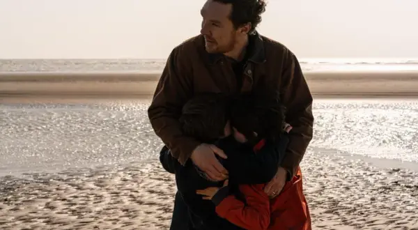 En man kramar sina barn på stranden. En scen som känns som en av de där comfort movies man vill se om och om igen.