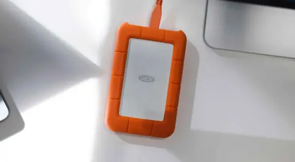 Pomarańczowy dysk LaCie z logo, podłączony kablem. Idealny do backupu danych w trybie raid 1.
