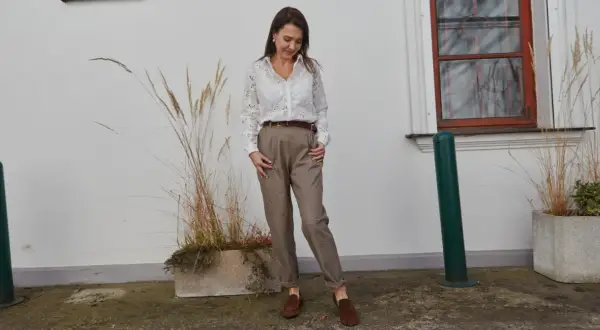 Elegancka stylizacja do pracy: biała koszula z haftem, brązowe spodnie i mokasyny. Inspiracja, jak się ubrać do pracy.