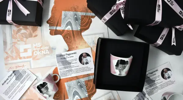 Kolekcja produktów z grafiką Andrzeja Pągowskiego, w tym kubek i pudełka, ozdobione są charakterystycznymi sylwetkami.