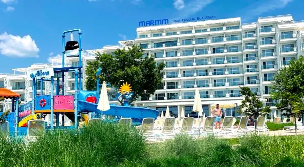 Hotel Paradise Blue Albena z placem zabaw wodnym i leżakami na tle błękitnego nieba.