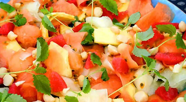 En färgglad melonsallad med ananas, passionsfrukt och nötter, perfekt som melonsallad till grillat.