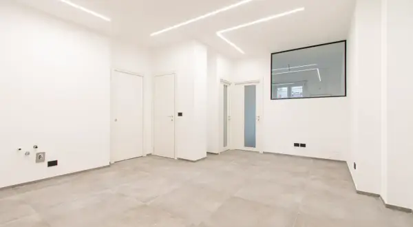 Interno moderno con pavimenti chiari, porte bianche e luci a led sul soffitto. Ideale per chi deve ristrutturare casa e cerca un ambiente luminoso e pulito.