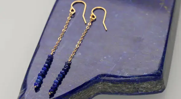 Eleganckie kolczyki z lapis lazuli na złotym łańcuszku, zakończone wygodnym zapięciem bigiel.