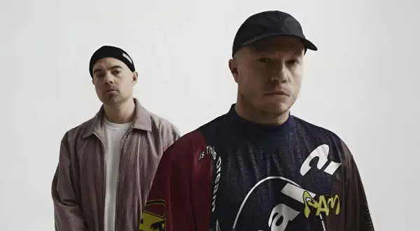 Dwóch mężczyzn w czapkach, jeden w sztruksowej kurtce, drugi w bluzie z napisem "Is this dream". Czy to zapowiedź problem koncertów 2025?