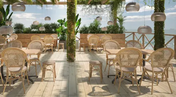 Terrasse mit Rattanmöbeln und Blick aufs Meer.
