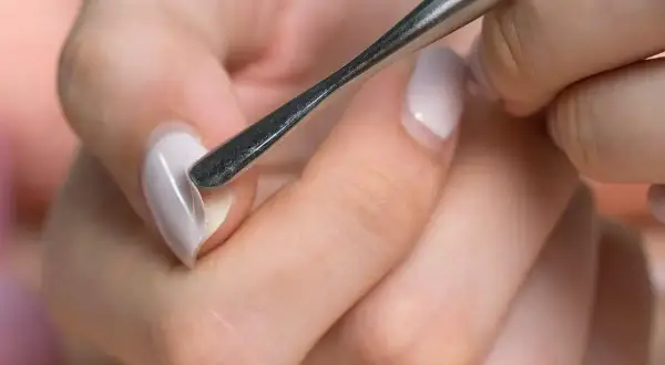 Manicure con attrezzo per cuticole, un passo fondamentale per imparare come fare le unghie in gel a casa e ottenere un risultato professionale.
