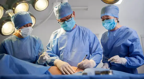 Chirurdzy w maseczkach i fartuchach operują. Czas jest kluczowy, gdy trzeba szybko operować raka.