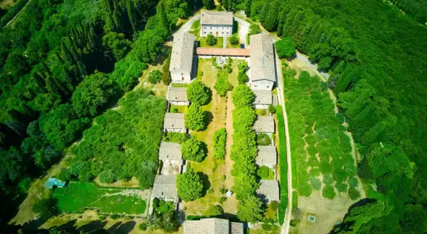 Vista aerea dell'eremo di San Giorgio, un complesso di edifici circondato da un rigoglioso bosco.