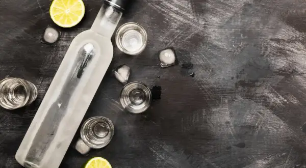 Butelka wódki, kieliszki, lód i limonka. Idealne składniki, by dowiedzieć się, jak rozcieńczyć spirytus.