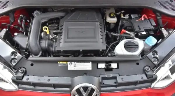Silnik 1.0 TSI w czerwonym samochodzie Volkswagen. Widoczny akumulator, płyny i elementy układu dolotowego.