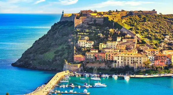 Porto Azzurro, un gioiello da scoprire tra le cose da visitare in Toscana. Un borgo colorato con un porto turistico e un'antica fortezza sul promontorio.