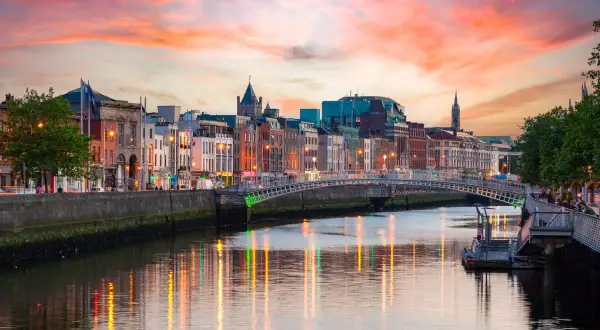 Zachód słońca nad rzeką Liffey, gdzie jest Dublin. Widać most Ha'penny i kolorowe kamienice.