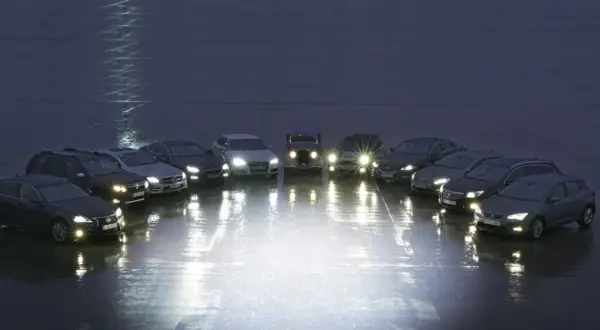 Różne rodzaje lamp samochodowych prezentowane na tle nocnego nieba. Od klasycznych reflektorów po nowoczesne LED-y, każdy pojazd oświetla drogę na swój sposób.