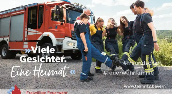 Feuerwehr mitgliederwerbung ideen: Eine Gruppe lacht und tanzt vor einem Feuerwehrauto. Sie zeigen, dass die Feuerwehr eine #feuerwehrfamilie ist.