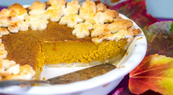 Ein leckerer Kürbiskuchen, dekoriert mit Blätter-Ausstechern, perfekt für Halloween.