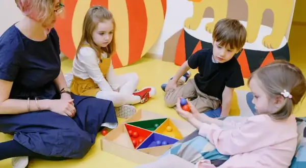 Dzieci z zaburzeniami czucia głębokiego ćwiczą koordynację, bawiąc się kolorowymi kulkami.
