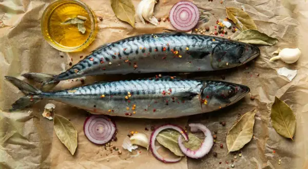 Två hela makrillar med kryddor, lökringar, vitlök och olja. Makrill nyttigt och gott att tillaga!
