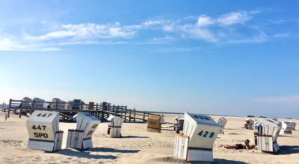 Strandkörbe am Strand von St. Peter-Ording, die Innenstadt ist nicht zu sehen, aber die typische Urlaubsatmosphäre ist spürbar.