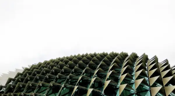 Edificio con facciata a squame triangolari, che ricorda i materiali a cambiamento di fase per la sua struttura dinamica e adattiva.