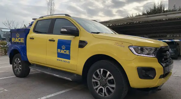 Camioneta amarilla y azul del RACE, lista para la acción. Su diseño es ideal para cualquier tipo de carrera o servicio.