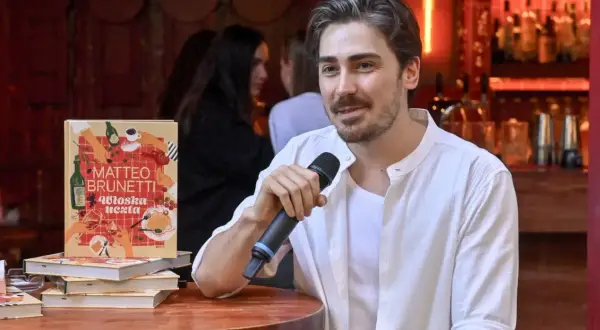 Matteo Brunetti z mikrofonem obok swojej książki "Włoska uczta". Czy popularny kucharz naprawdę uczył się gotować w zagranicznej rodzinie?