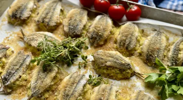 Acciughe ripiene alla ligure, dorate e croccanti, pronte per essere gustate. Un piatto che profuma di mare e tradizione.