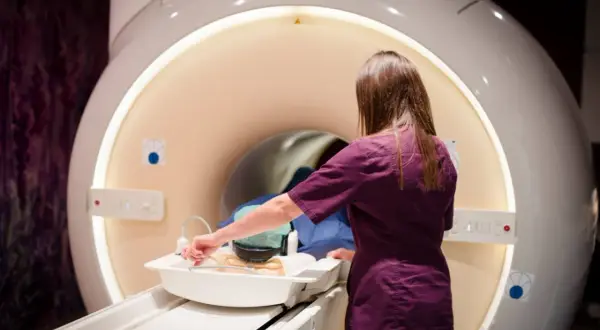 Technik przygotowuje pacjenta do badania rezonansem magnetycznym. Ważne, by implanty ze stali chirurgicznej nie stanowiły przeciwwskazania.