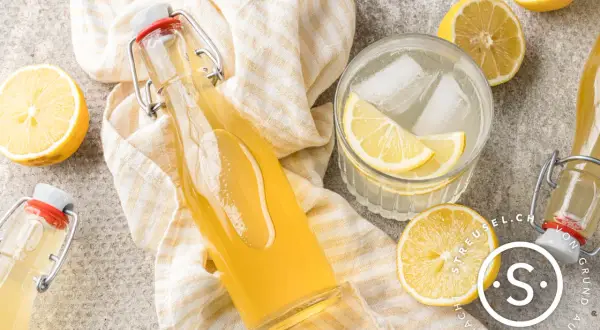 Erfrischender Zitronensirup im Glas mit Eis und Zitronenscheiben. Ein tolles Rezept für selbstgemachten Zitronensirup.