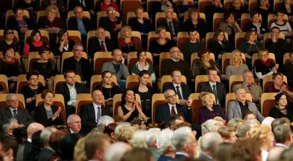 Elegancko ubrani widzowie siedzą w filharmonii, zastanawiając się, jak się ubrać do filharmonii.