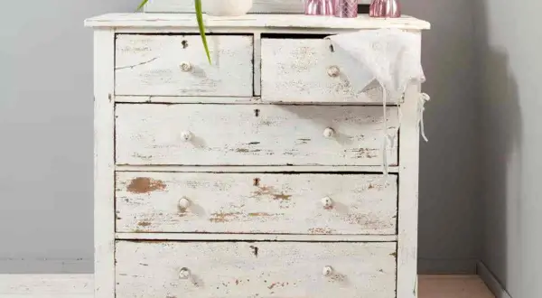 Comò in legno decapato bianco, con cassetti consumati che raccontano storie di un tempo.