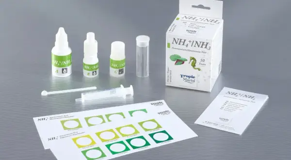Zestaw do testowania poziomu **nh4** w akwarium: buteleczki z odczynnikami, probówka, strzykawka i karta porównawcza kolorów.