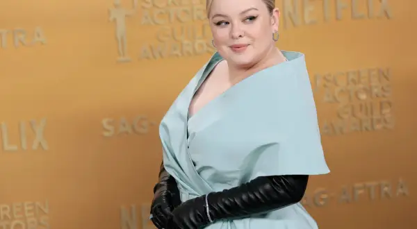Nicola Coughlan, con su altura destacada, posa con un elegante vestido azul pálido y guantes negros en los Screen Actors Guild Awards.